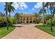 Grand entrance with brick driveway, fountain, and palm trees at 1067 Westway Dr, Sarasota, FL 34236