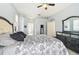 Large main bedroom suite with tile floors, a ceiling fan, and modern black furnishings at 10726 Old Grove Cir, Bradenton, FL 34212