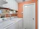 Bright laundry room featuring white appliances, shelving, and storage cabinets at 10726 Old Grove Cir, Bradenton, FL 34212