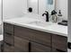 Close up of modern bathroom vanity with stylish white countertop, dark wood cabinets, and black faucet at 114 Francis Ne Dr, Port Charlotte, FL 33952