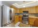 The well-lit kitchen offers stainless steel appliances, wooden cabinets, and tiled backsplash at 1208 Francis Ave, Sarasota, FL 34232