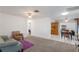 Open-concept living room transitioning to dining area, featuring neutral carpet and white tile at 1208 Francis Ave, Sarasota, FL 34232