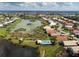 Aerial view of the community, showcasing a lake, well-maintained landscaping, and single-Gathering homes at 1358 Berkshire Ct, Venice, FL 34292