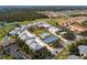 Aerial view of the property featuring a community pool, tennis court, lush landscaping, and walking paths at 1358 Berkshire Ct, Venice, FL 34292