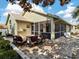 Backyard patio features an outdoor fire pit with chairs, lush landscaping, and screened lanais at 1358 Berkshire Ct, Venice, FL 34292