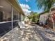 Landscaped backyard with a screened-in lanai, outdoor seating, and a stone pathway at 1358 Berkshire Ct, Venice, FL 34292