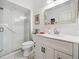 Bright bathroom features a walk-in shower with glass door, a toilet, and a vanity with white cabinets at 1358 Berkshire Ct, Venice, FL 34292