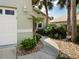 Close-up of lush landscaping featuring palms and decorative rock on the side of home at 1358 Berkshire Ct, Venice, FL 34292