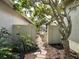 Charming garden gate leading to serene backyard, framed by lush greenery and mature trees for privacy at 1358 Berkshire Ct, Venice, FL 34292