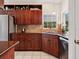 Kitchen area featuring stainless steel appliances, granite countertops, and wood cabinetry at 1358 Berkshire Ct, Venice, FL 34292