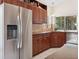 Bright kitchen featuring stainless steel refrigerator and wood cabinetry at 1358 Berkshire Ct, Venice, FL 34292