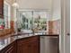 Stainless steel dishwasher and sink with backyard view in kitchen at 1358 Berkshire Ct, Venice, FL 34292