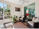 Screened lanai with tile floors, ceiling fan, and comfortable seating area at 1358 Berkshire Ct, Venice, FL 34292