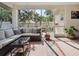 Relaxing screened lanai with comfortable sofa and view of the backyard and mature landscaping at 1358 Berkshire Ct, Venice, FL 34292