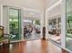 Open living area featuring hardwood floors with view of dual screened lanais through sliding glass doors at 1358 Berkshire Ct, Venice, FL 34292