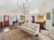 Bright living room featuring vaulted ceilings, elegant chandelier, and warm wood floors at 1358 Berkshire Ct, Venice, FL 34292