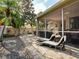 Relaxing patio with chaise lounges, screened lanai, and lush landscaping offering a private outdoor retreat at 1358 Berkshire Ct, Venice, FL 34292