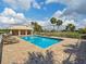 Community pool with clear blue water, surrounded by brick patio, lounge chairs, and a covered cabana at 1358 Berkshire Ct, Venice, FL 34292