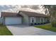 Single-story home features manicured front lawn and a two-car garage at 1406 14Th Street W Ct, Palmetto, FL 34221