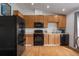 Efficient kitchen layout featuring wood cabinetry, black appliances, and a functional design for everyday convenience at 1406 14Th Street W Ct, Palmetto, FL 34221