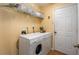Clean laundry room with a washer and dryer, shelving for storage, and a door at 1406 14Th Street W Ct, Palmetto, FL 34221