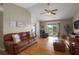A cozy living room featuring hardwood floors, a ceiling fan, a sliding glass door, and comfortable seating at 1406 14Th Street W Ct, Palmetto, FL 34221