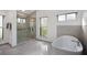 Bathroom with walk-in glass shower, soaking tub, and natural lighting at 1529 Oak Way, Sarasota, FL 34232