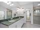 Bathroom with large vanity featuring granite countertop, and a glass-enclosed shower at 1529 Oak Way, Sarasota, FL 34232