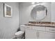 Bathroom with patterned wallpaper, dual sinks with granite countertop, and oval mirror above the sink at 1529 Oak Way, Sarasota, FL 34232
