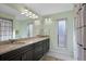 Bathroom with double sink vanity, granite countertops, and a large mirror with modern lighting at 1529 Oak Way, Sarasota, FL 34232