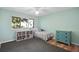 Light and airy bedroom with a soft gray rug, turquoise dresser, and built-in shelving unit at 1529 Oak Way, Sarasota, FL 34232