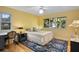 Bright bedroom with yellow walls, area rug, ceiling fan, and windows providing natural light at 1529 Oak Way, Sarasota, FL 34232