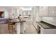 Bright kitchen with granite countertops, custom white cabinets, and seating at the island at 1529 Oak Way, Sarasota, FL 34232