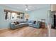 Living room with large L-shaped sofa and hardwood floors, featuring natural light from the window at 1529 Oak Way, Sarasota, FL 34232