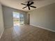 Bedroom featuring a ceiling fan, tile floors, and sliding glass door leading to the lanai at 18053 Ohara Dr, Port Charlotte, FL 33948