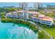 Stunning aerial view of the waterfront condominium complex with lush landscaping and serene turquoise waters at 225 Sands Point Rd # 6204, Longboat Key, FL 34228