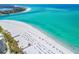 Beautiful aerial view of a pristine white sandy beach and turquoise ocean waters filled with beachgoers at 225 Sands Point Rd # 6204, Longboat Key, FL 34228