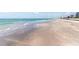 Scenic shot of a calm beach with clear waters and distant buildings at 225 Sands Point Rd # 6204, Longboat Key, FL 34228