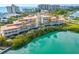 Exterior view of a modern waterfront condo featuring balconies and lush landscaping at 225 Sands Point Rd # 6204, Longboat Key, FL 34228