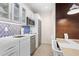 Well-equipped kitchenette with white cabinetry, stainless steel appliances, and stylish backsplash detail at 225 Sands Point Rd # 6204, Longboat Key, FL 34228