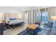 Serene main bedroom featuring a comfortable bed, a cozy sitting area, and access to a private balcony at 225 Sands Point Rd # 6204, Longboat Key, FL 34228