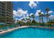Resort-style pool surrounded by palm trees and luxurious lounge chairs at 225 Sands Point Rd # 6204, Longboat Key, FL 34228