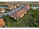 Aerial view of townhomes featuring tile roofs, screened lanais, and lush landscaping in a waterside community at 23189 Banbury Way # 203, Venice, FL 34293