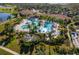 A scenic aerial view captures the expansive community pool, lush landscaping, and beautiful clubhouse at 23189 Banbury Way # 203, Venice, FL 34293