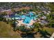 A stunning aerial view showcases the resort-style pool, lush greenery, and community amenities at 23189 Banbury Way # 203, Venice, FL 34293