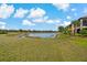 Scenic backyard view overlooking a serene lake and lush landscaping in a beautiful community at 23189 Banbury Way # 203, Venice, FL 34293