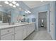 Bright bathroom featuring a double vanity with white cabinets and a walk-in closet at 23189 Banbury Way # 203, Venice, FL 34293
