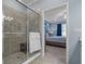 Bathroom with glass shower, tiled walls, bench and view into the main bedroom at 23189 Banbury Way # 203, Venice, FL 34293