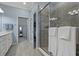 Bathroom featuring walk-in shower, double vanity, and view to walk-in closet and toilet at 23189 Banbury Way # 203, Venice, FL 34293