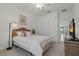 Bedroom with a white bed, wicker headboard, and an adjacent view of the living room at 23189 Banbury Way # 203, Venice, FL 34293